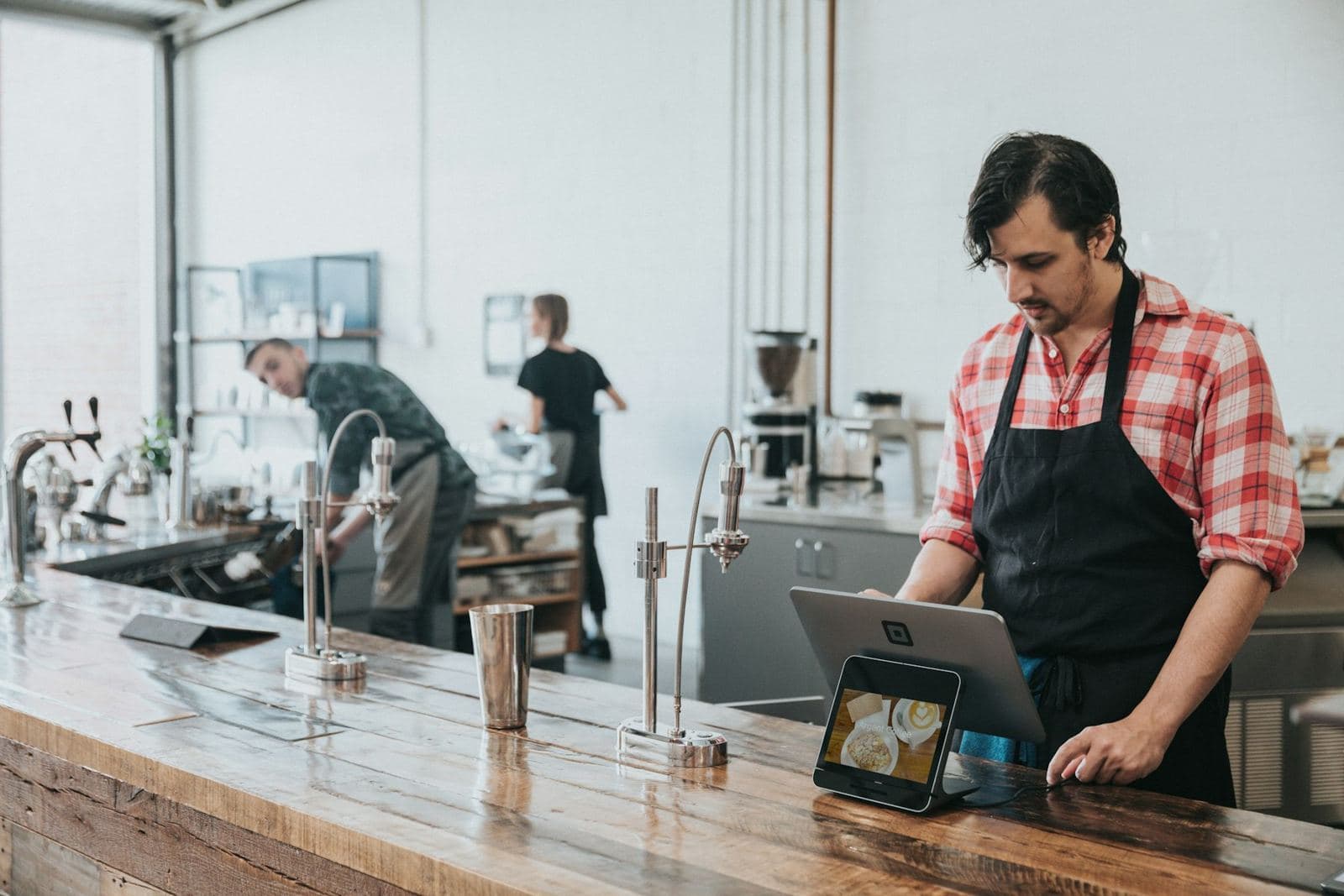 A barista checking orders on a tablet