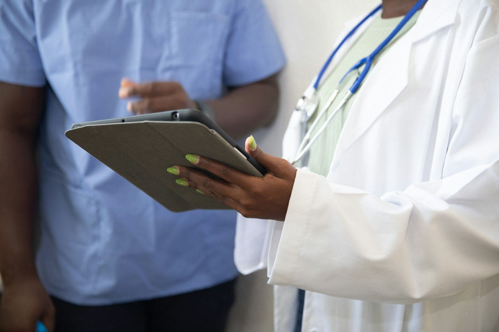 A clinic receptionist checking the day's bookings on a tablet